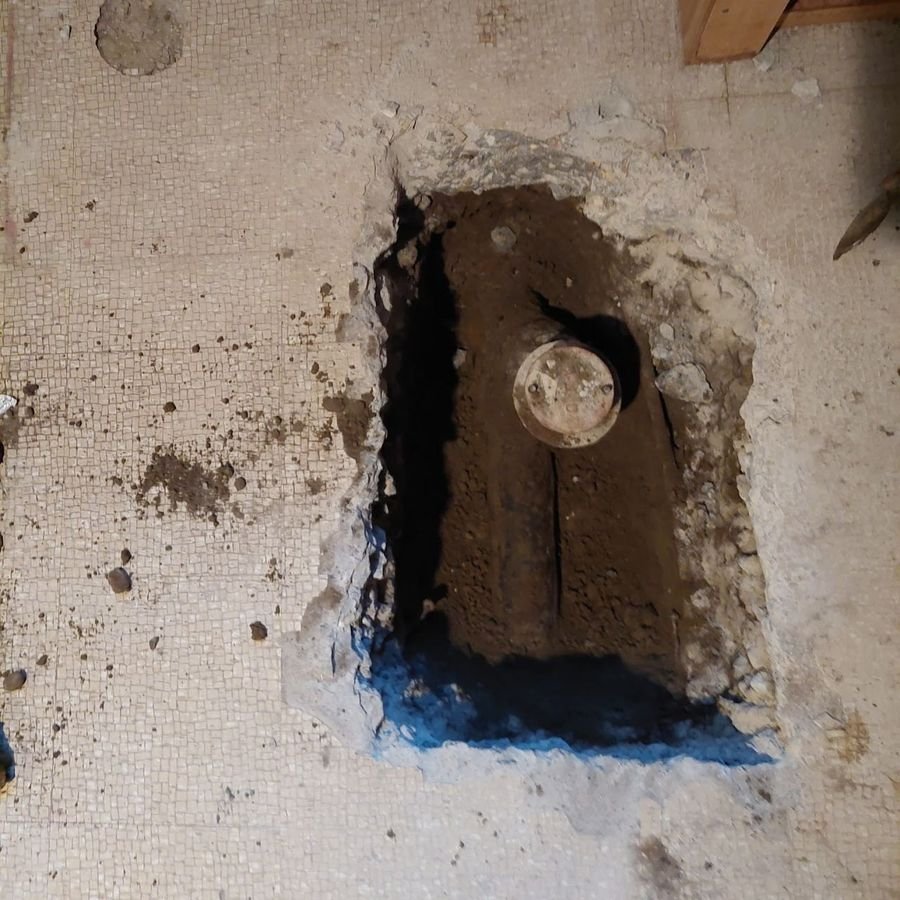 The main sewer exposed in the opened floor, ready for the backwater valve